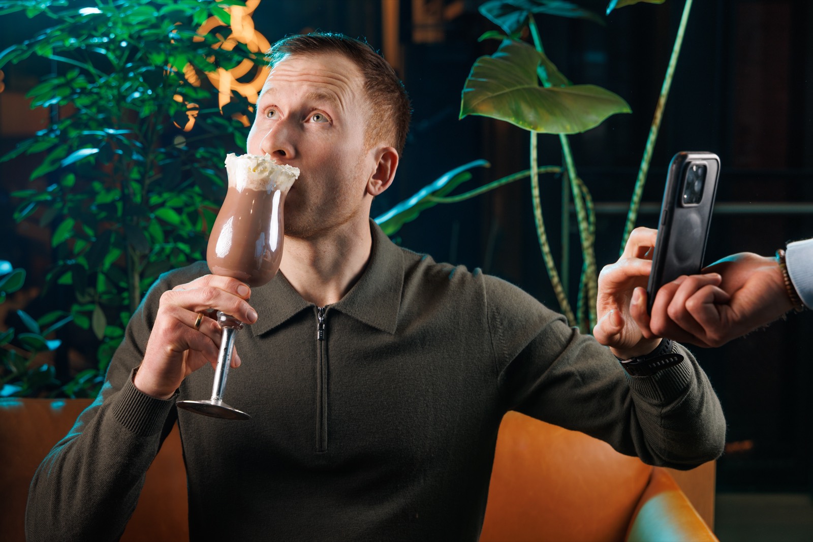 Erlend Haddeland med kakao i den ene hånden og telefonen i den andre